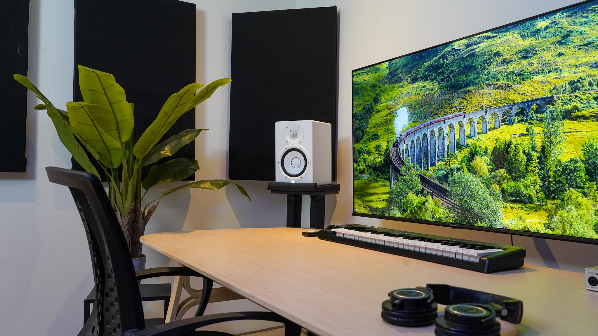 Werkplek met studio monitors, MIDI-keyboard en groot scherm